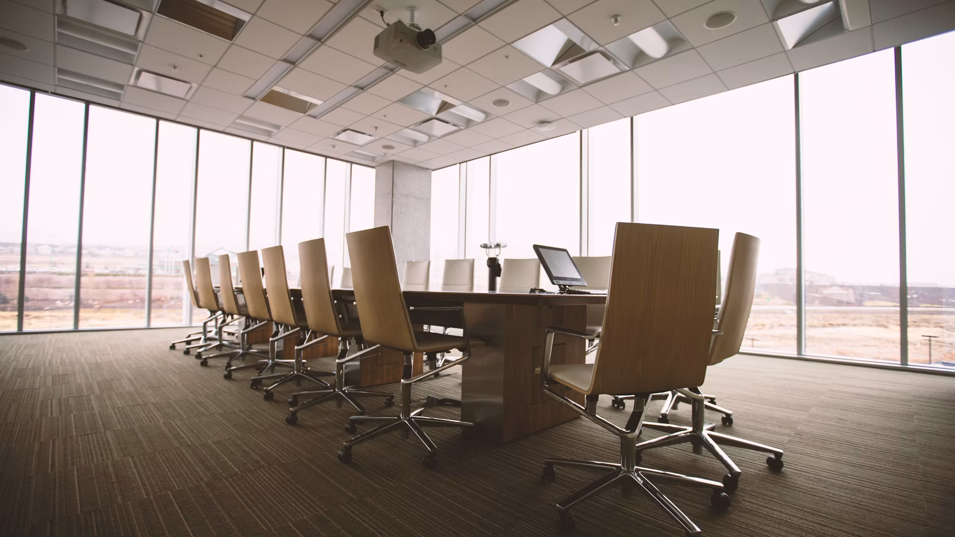 An empty boardroom with floor-to-ceiling windows, ready for the meeting